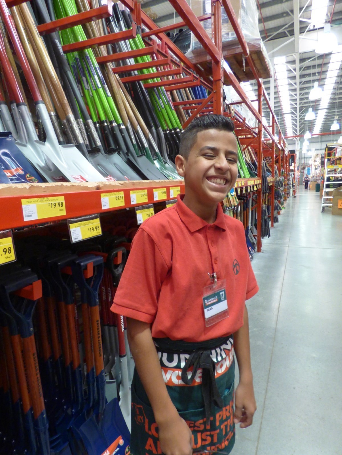 Fara standing in his Bunnings uniform at Bunnings in front of the shovel section
